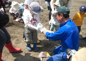 とうきびの種をもらう子ども